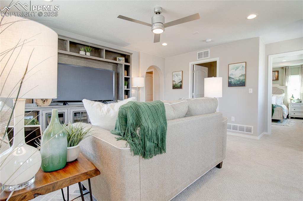 Image 14 of 23: Living room featuring arched walkways, carpet flooring, ceiling fan, recess