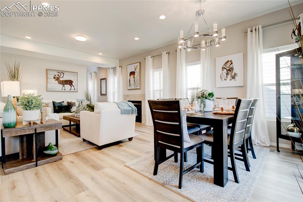 Image 9 of 23: Dining area with a chandelier, recessed lighting, a fireplace, and light wo