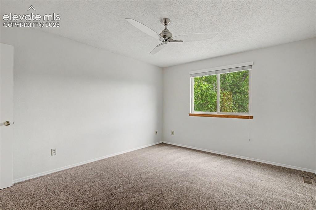 Image 20 of 30: Neutral wall paint, textured ceiling, and plush carpeting