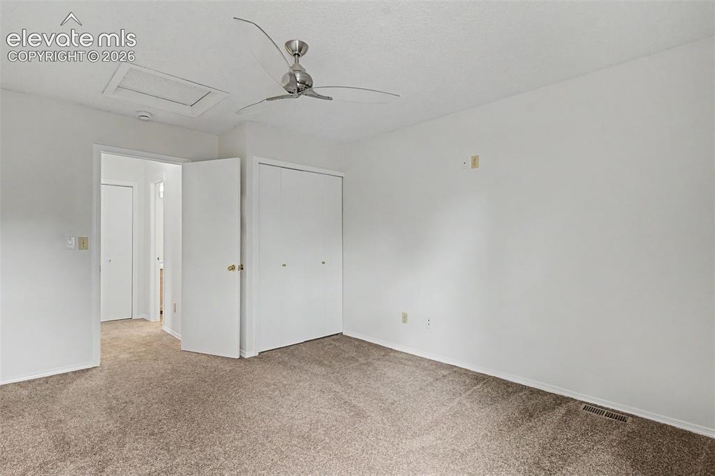 Image 21 of 30: Carpeted interior space featuring a ceiling fan with brushed nickel accents