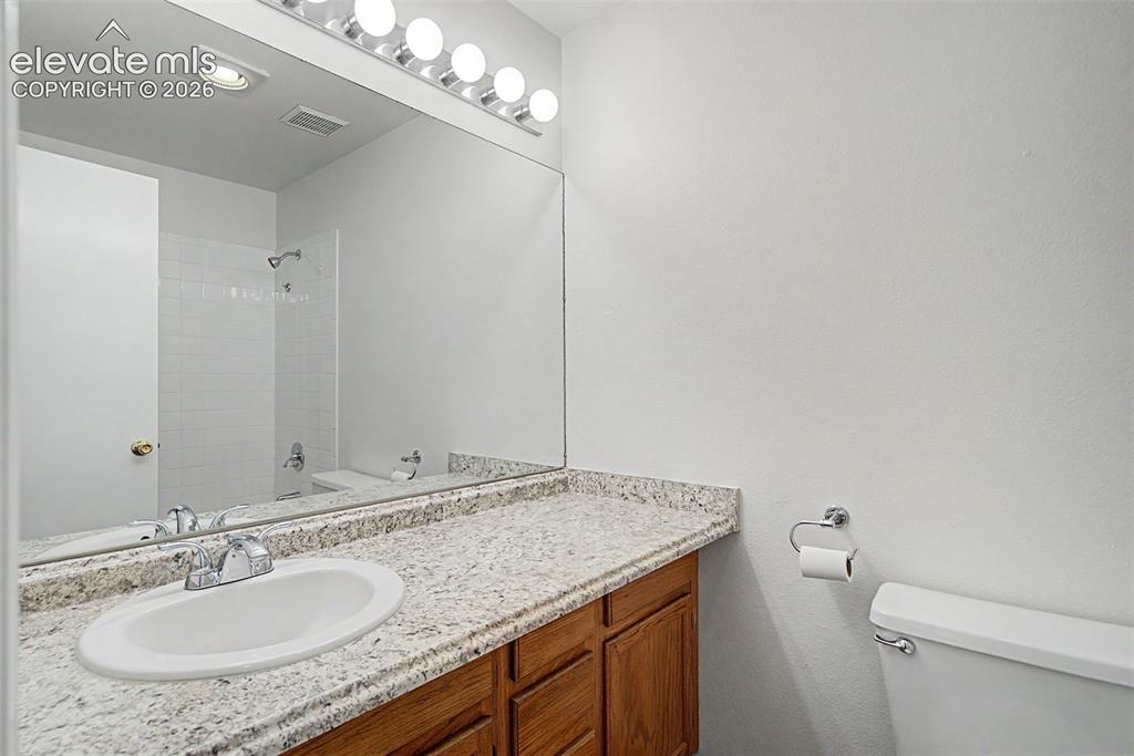 Image 23 of 30: Bathroom vanity with an integrated oval sink, chrome faucet, and a light-to