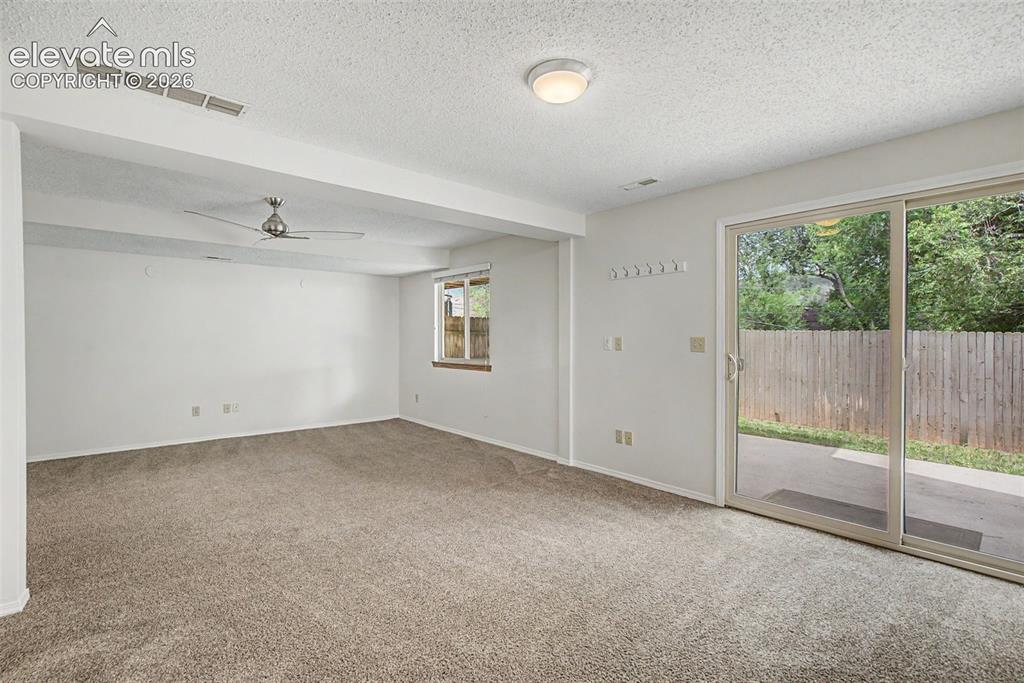 Image 25 of 30: Carpeted room featuring a ceiling fan, recessed window with wood trim, and