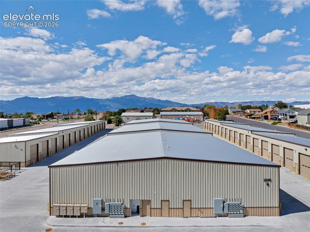 Image 10 of 20: Metal-sided storage facilities with multiple unit doors, concrete driveways