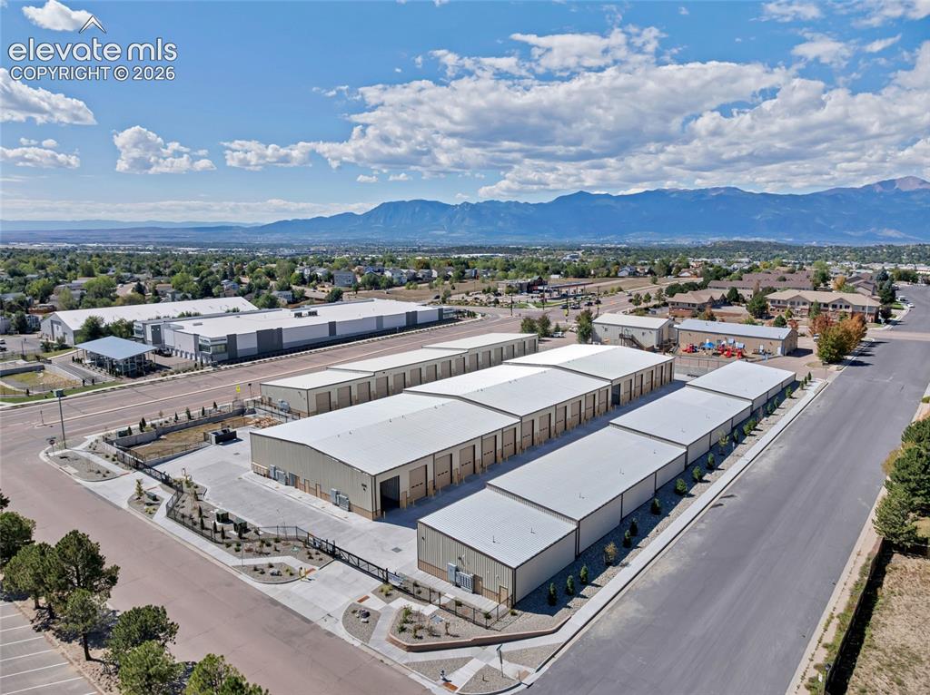 Image 12 of 20: Multiple industrial buildings with metal siding and roofs, surrounded by pa