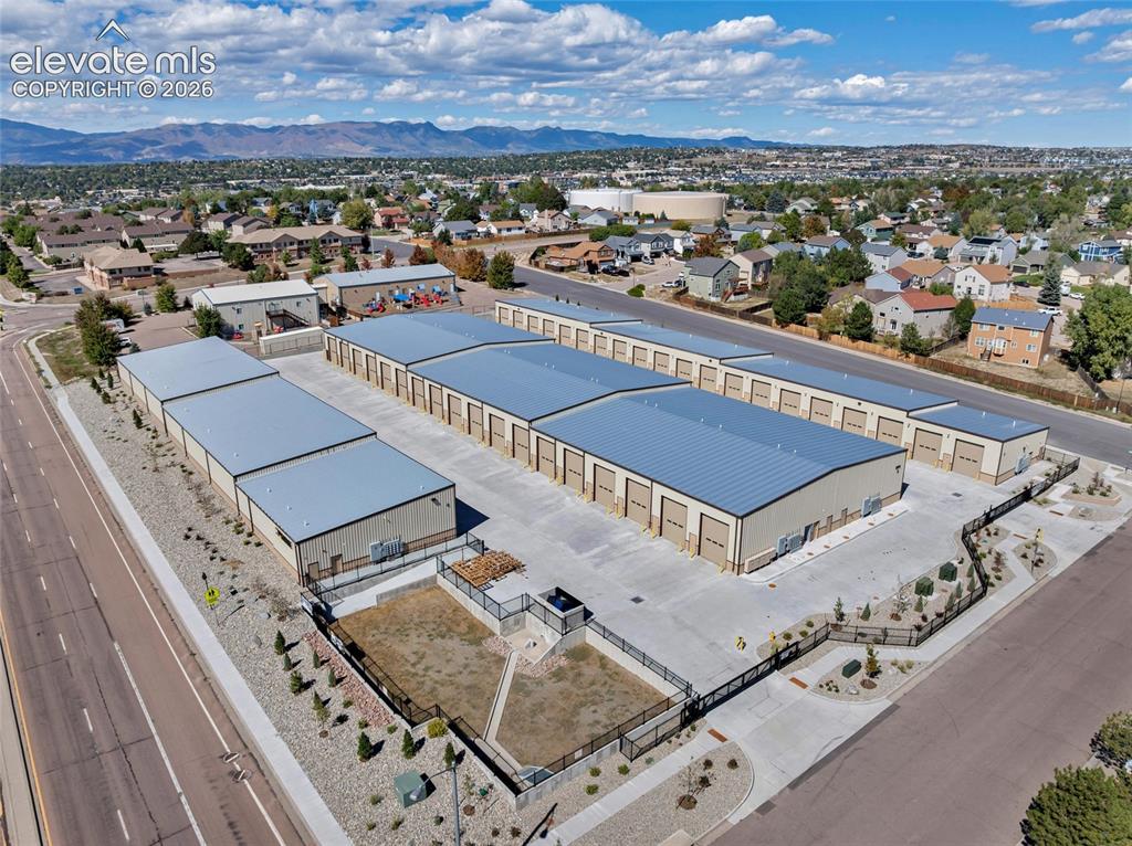 Image 14 of 20: Multiple storage buildings with gray metal roofs, numerous roll-up doors, c