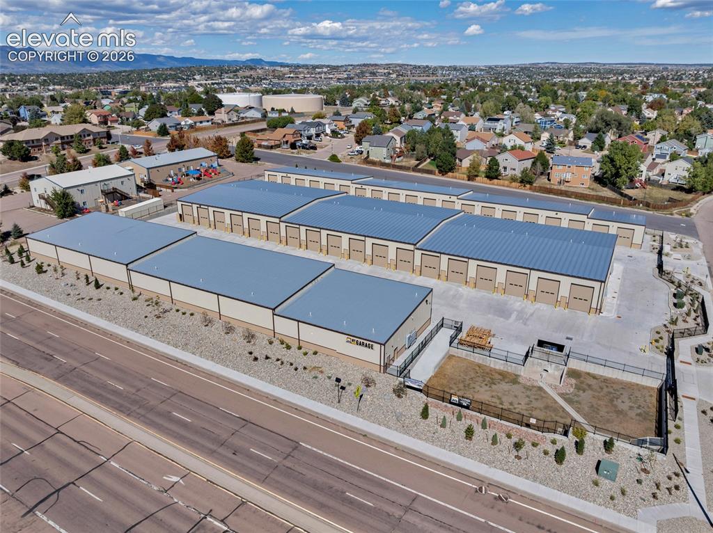 Image 15 of 20: Multiple storage buildings with metal roofs and roll-up doors