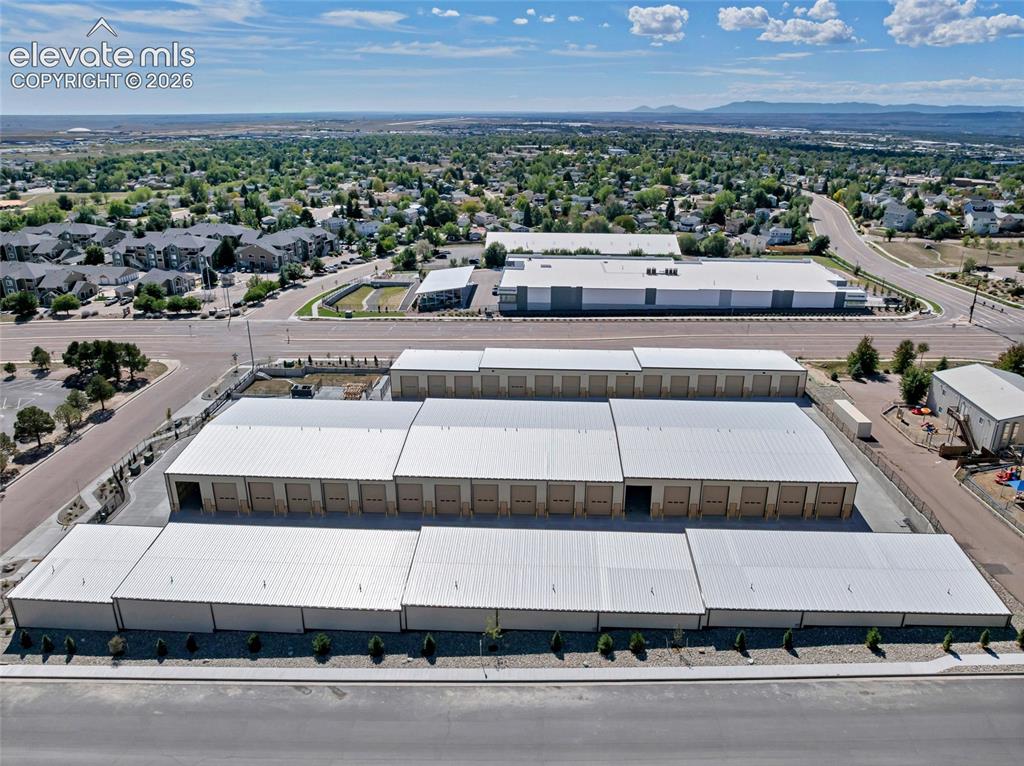 Image 17 of 20: Multiple storage buildings with metal roofs and roll-up doors