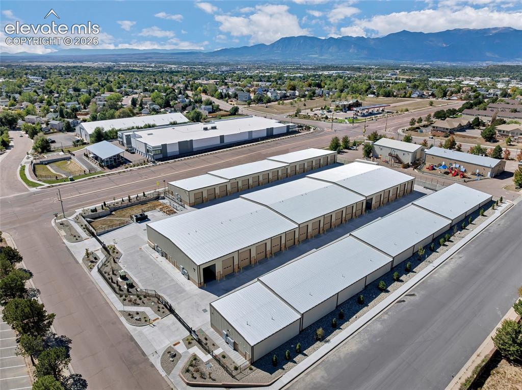 Image 18 of 20: Multiple storage buildings featuring roll-up doors, extensive paved access,