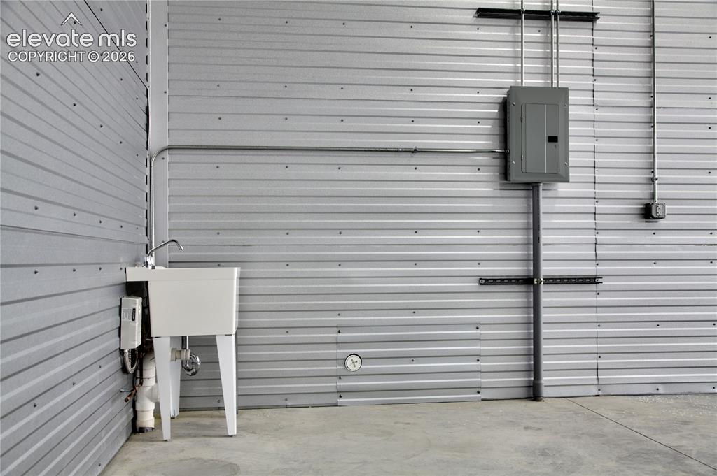 Image 4 of 20: Corrugated metal wall paneling with exposed conduit, electrical panel, util