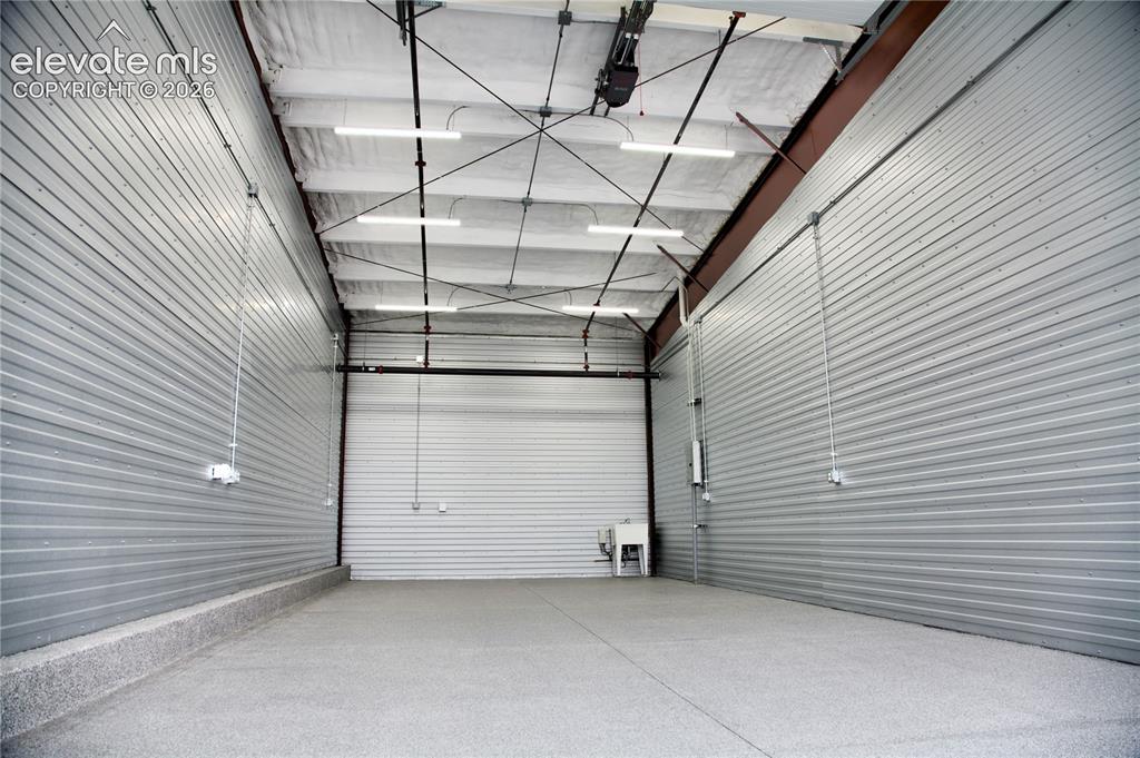 Image 5 of 20: Interior space featuring corrugated metal walls, a concrete floor with a te