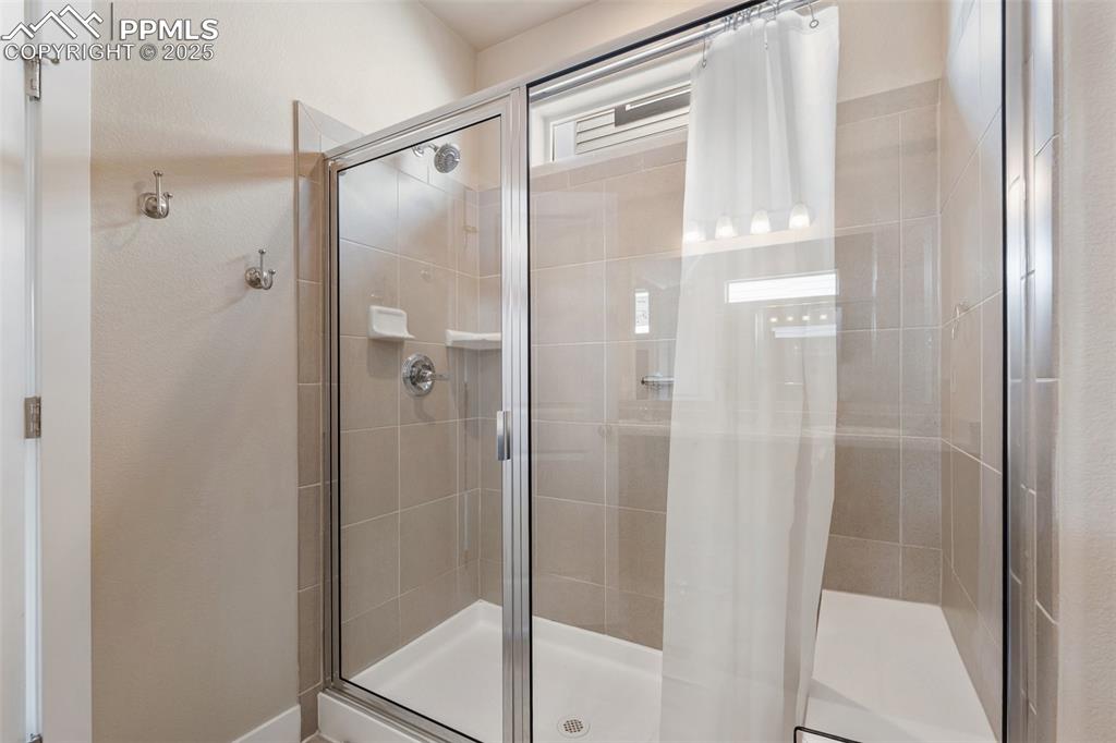 Image 30 of 49: Walk-in shower with added shower seat