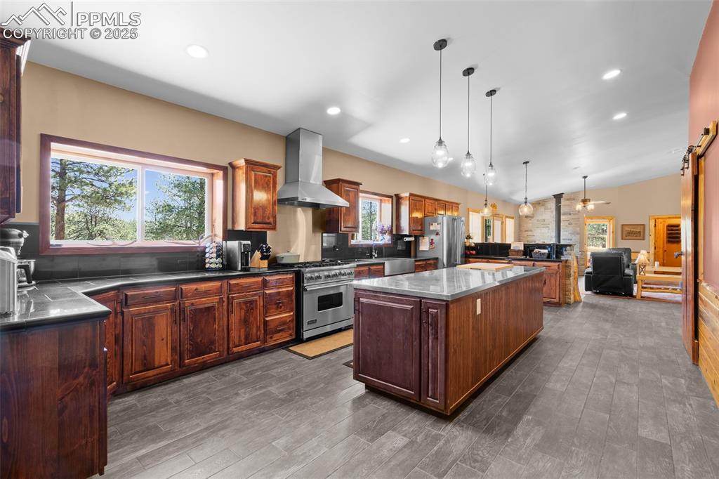 Image 11 of 40: Kitchen featuring a center island, healthy amount of natural light, wall ch