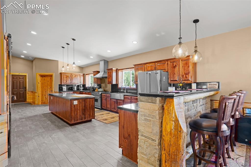 Image 14 of 40: Kitchen with dark countertops, a peninsula, light wood-style flooring, a ki