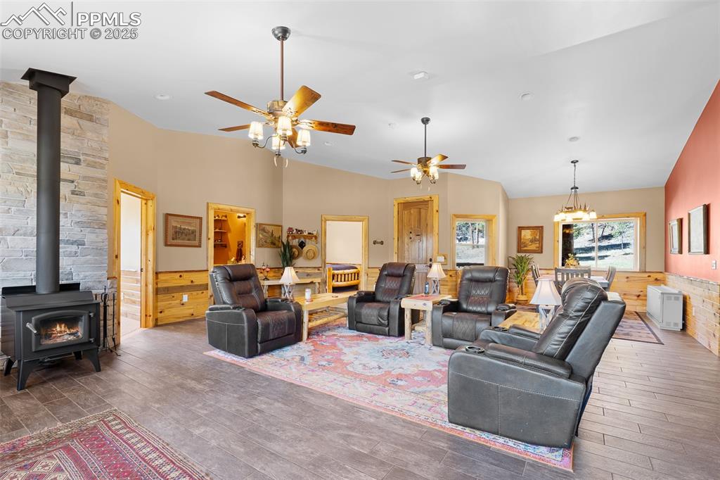 Image 16 of 40: Living room with a wood stove, ceiling fan, hardwood / wood-style flooring,