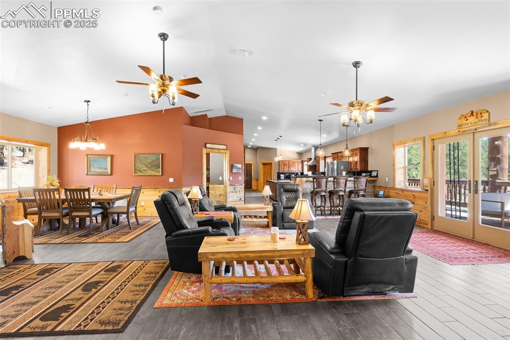 Image 17 of 40: Living room featuring a ceiling fan, lofted ceiling, wood finished floors,