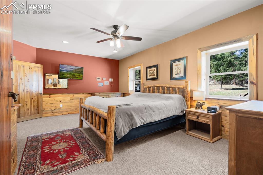 Image 21 of 40: Bedroom with carpet, wood walls, recessed lighting, and ceiling fan