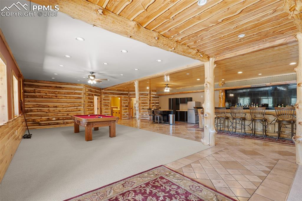 Image 30 of 40: Recreation room with bar, billiards table, recessed lighting, log walls, an