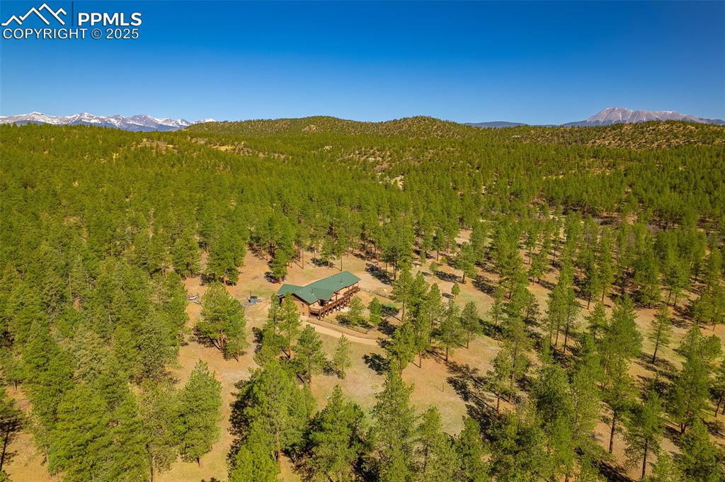 Image 39 of 40: Aerial view of property and surrounding area with a mountainous background