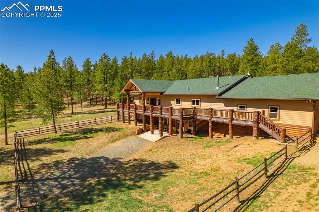 Image 4 of 40: Rear view of property featuring a deck, a shingled roof, and stairs