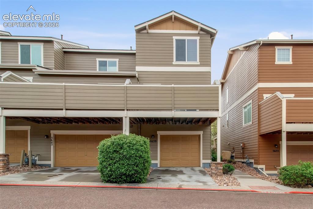 Image 5 of 22: Deck overhangs the driveway to the one car garag