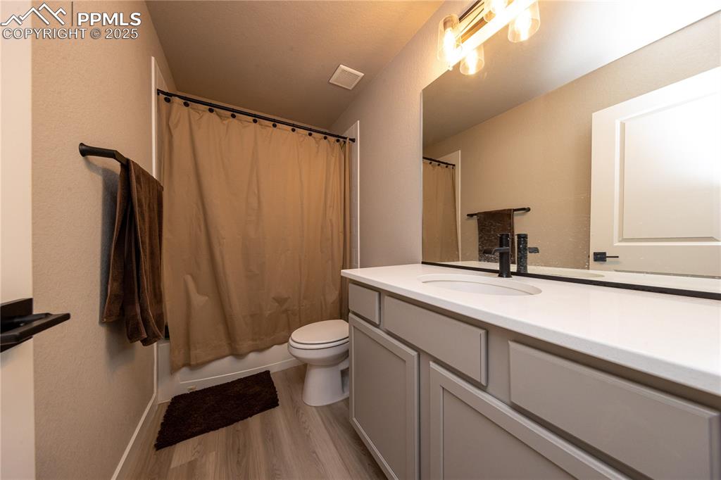 Image 19 of 32: Full bath featuring light wood-type flooring, vanity, and shower / bath com