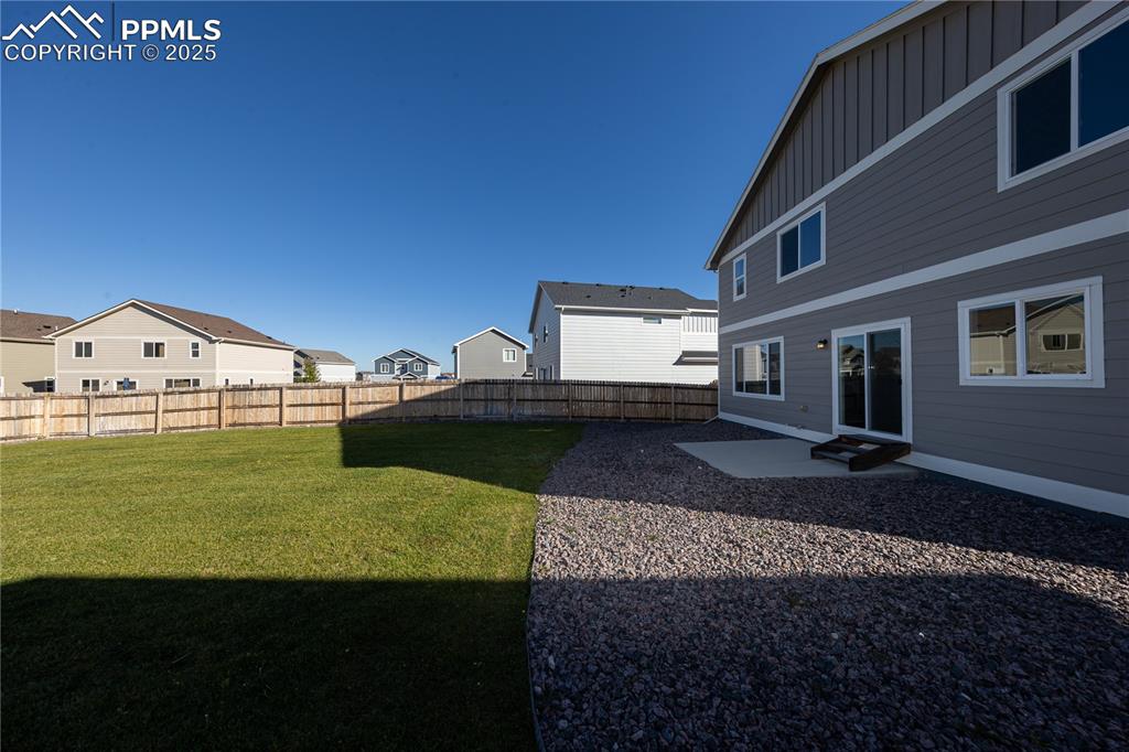 Image 30 of 32: Fenced backyard with a patio and a residential view