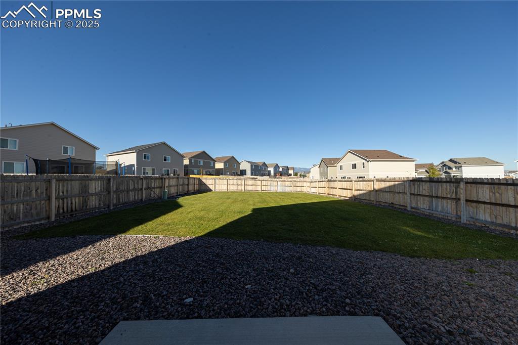 Image 32 of 32: Fenced backyard with a residential view