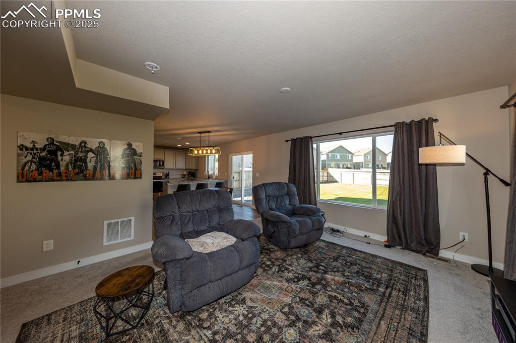 Image 8 of 32: Living room featuring carpet floors and a textured ceiling