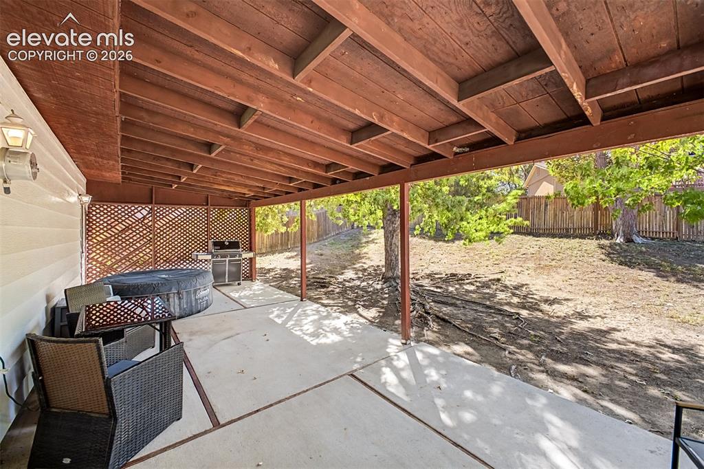 Image 12 of 44: Generous covered patio with a concrete flooring becomes extra living space 