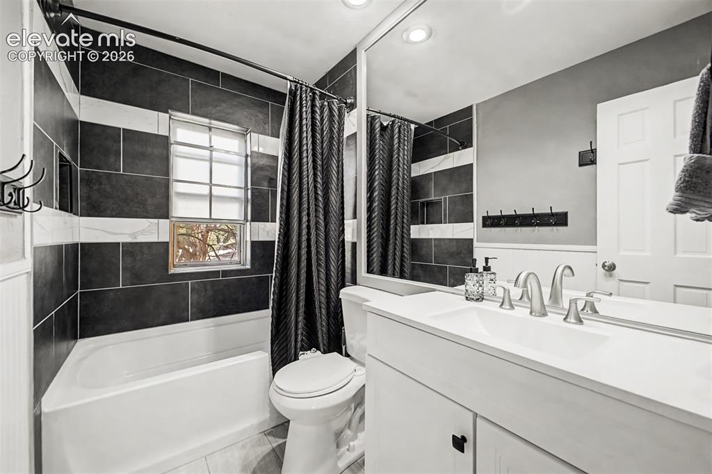 Image 16 of 44: Recently renoated upper level full bathroom with built-in bathtub, tile sur
