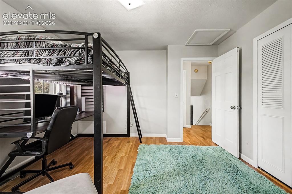 Image 18 of 44: Second upper level bedroom with two windows and LVP flooring also has extra
