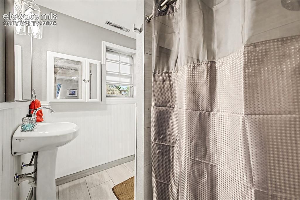 Image 23 of 44: Lower level bathroom with pedestal sink, wall-mounted medicine cabinets, up