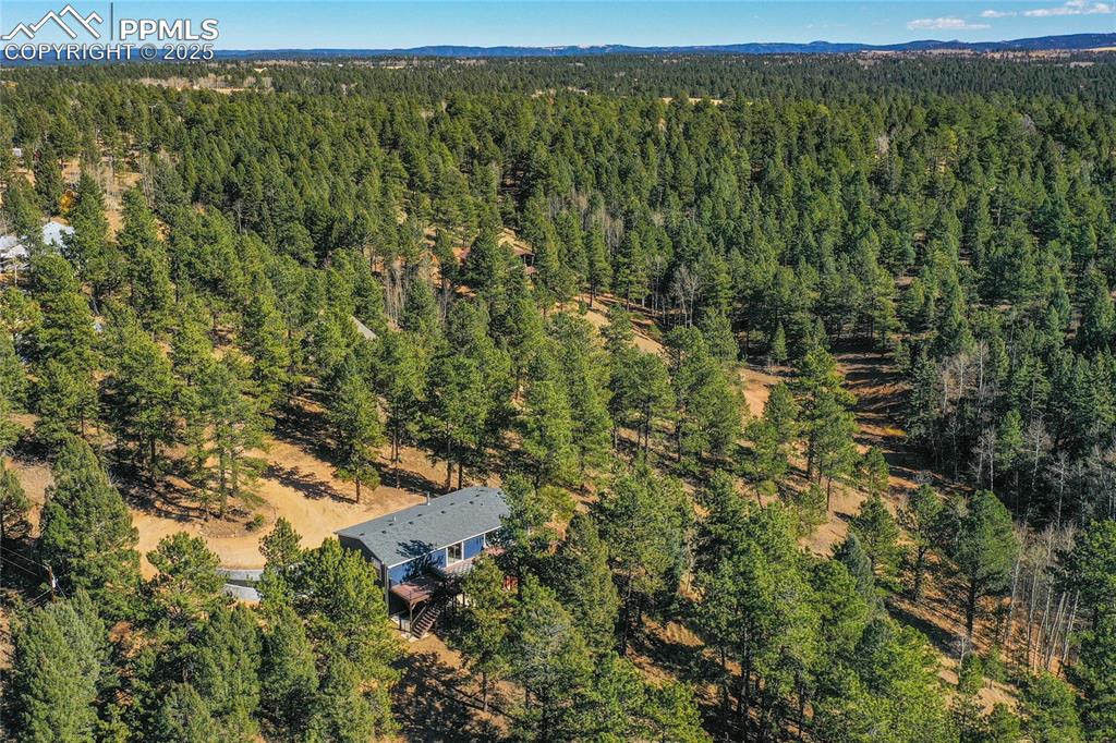 Image 14 of 47: Aerial view of property and surrounding area with a heavily wooded area
