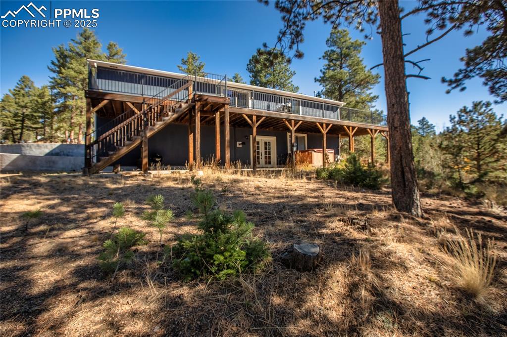 Image 17 of 47: Rear view of property with a deck, french doors, and stairs