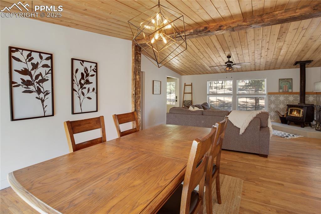 Image 19 of 47: Dining room featuring a wood stove, light wood finished floors, wooden ceil