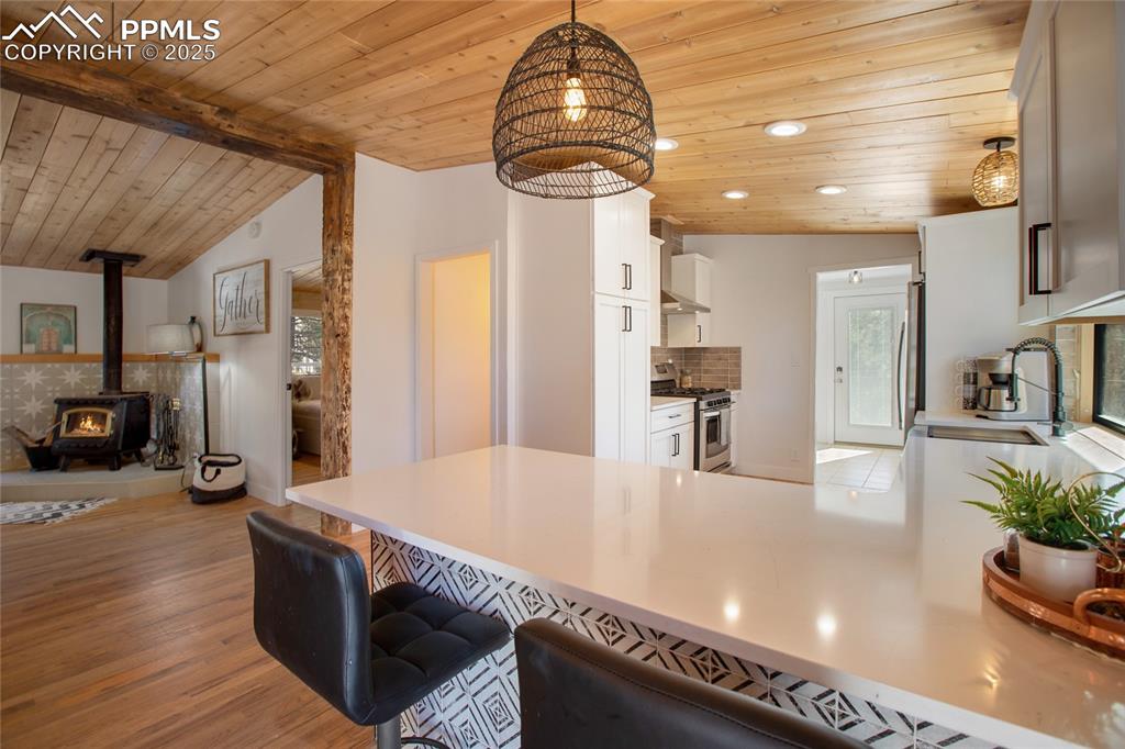 Image 21 of 47: Kitchen with gas stove, wooden ceiling, light wood-style flooring, plenty o