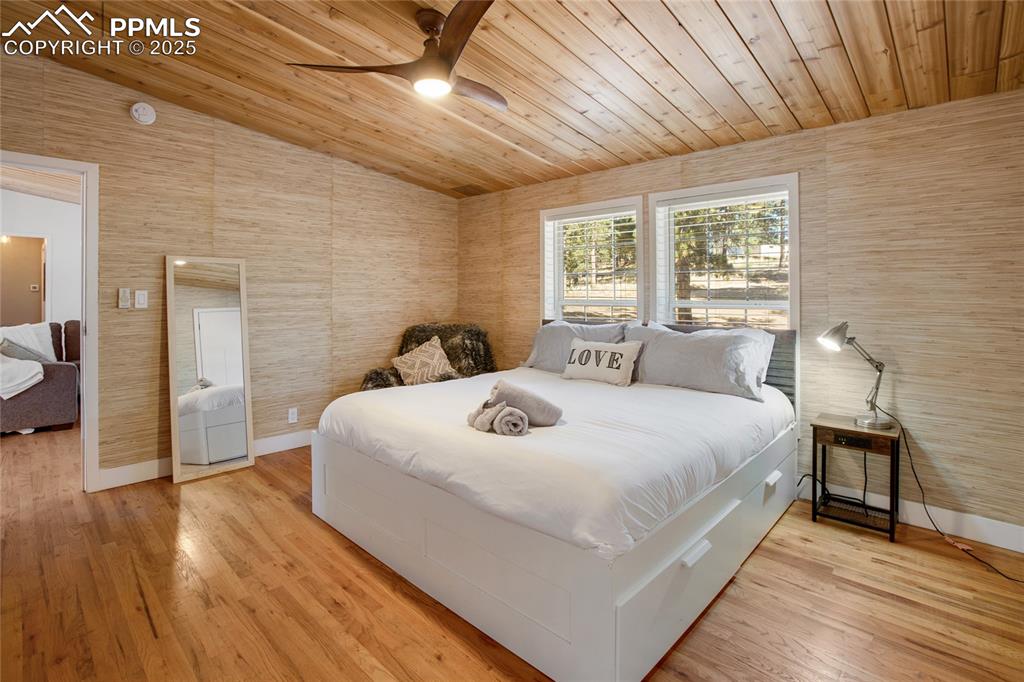Image 24 of 47: Bedroom featuring wooden ceiling, light wood-style flooring, a ceiling fan,
