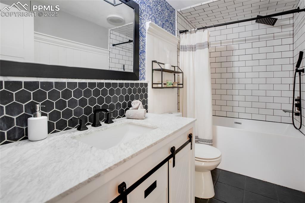 Image 31 of 47: Full bath featuring vanity, shower / bath combination with curtain, tile pa
