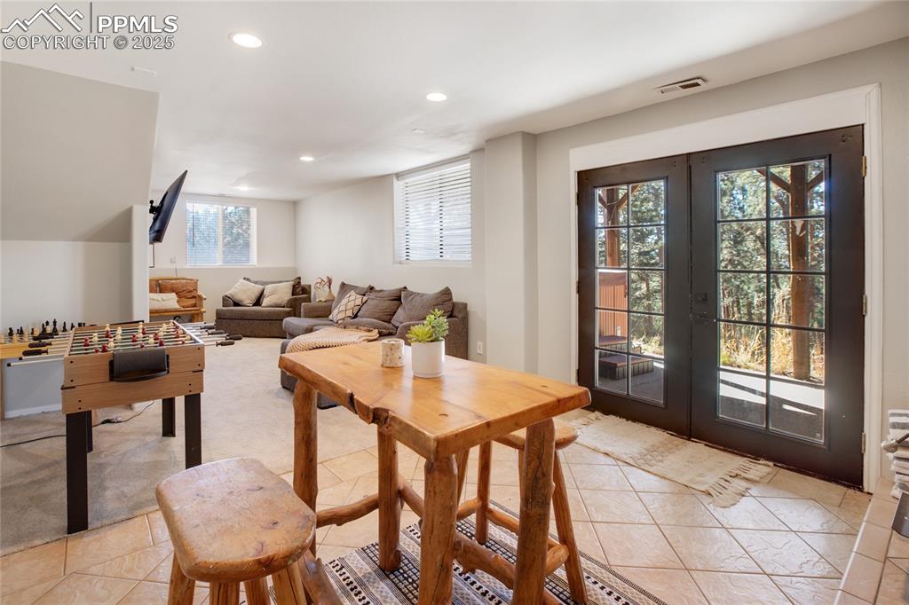 Image 32 of 47: Living area with french doors, recessed lighting, and light tile patterned 