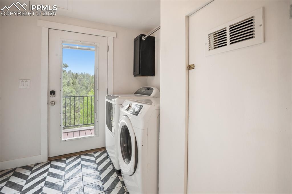 Image 39 of 47: Laundry area featuring washing machine and clothes dryer and cabinet space