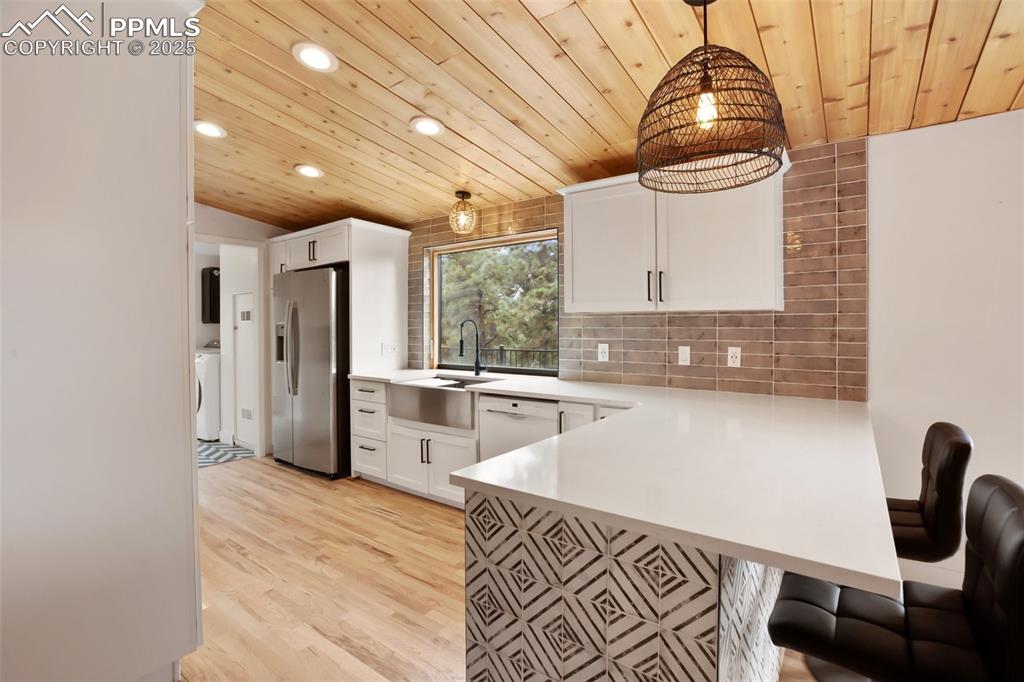 Image 9 of 47: Kitchen with stainless steel fridge, recessed lighting, dishwasher, wood ce
