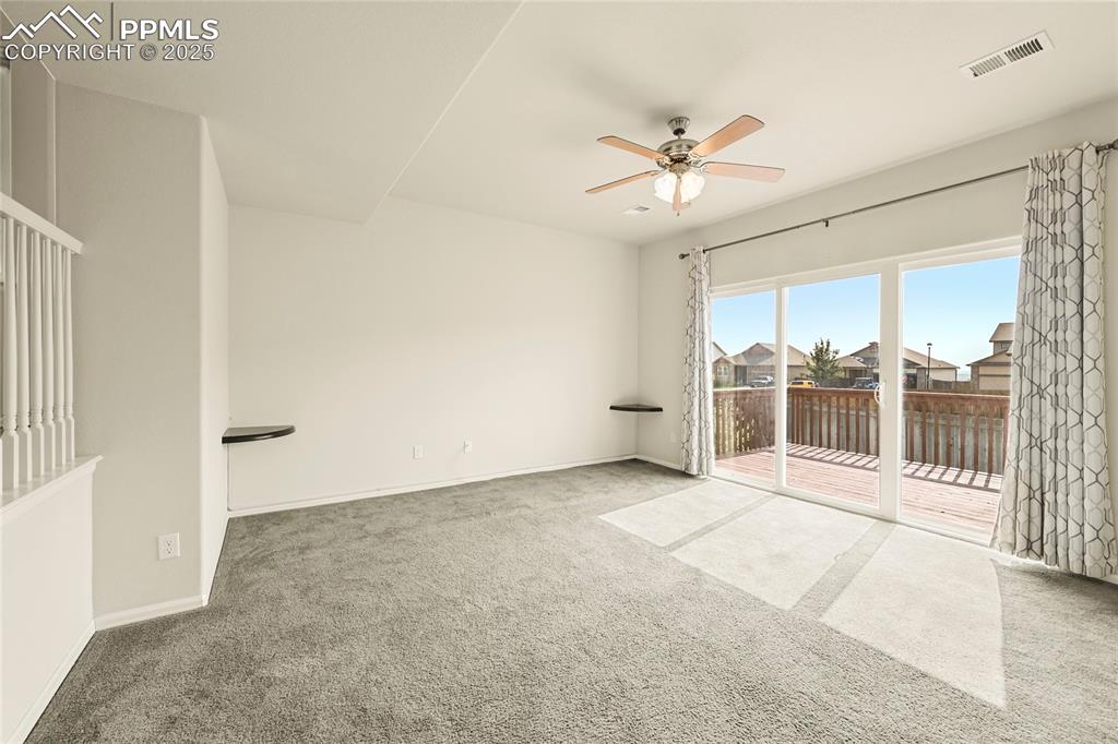 Image 10 of 28: Carpeted spare room with ceiling fan and a residential view