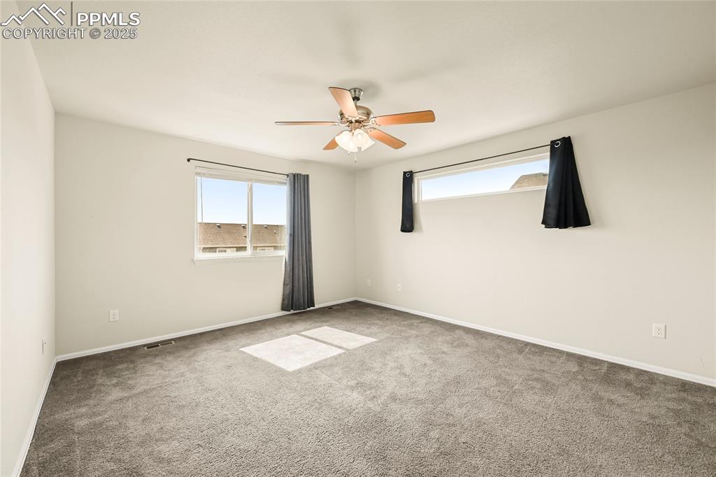 Image 14 of 28: Carpeted empty room featuring baseboards and a ceiling fan