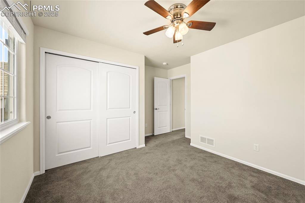 Image 19 of 28: Unfurnished bedroom featuring carpet, a closet, and ceiling fan