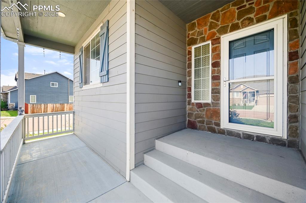 Image 2 of 28: View of exterior entry with stone siding and covered porch