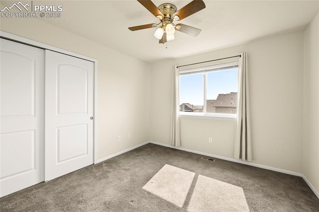 Image 20 of 28: Unfurnished bedroom with light carpet, a closet, and a ceiling fan