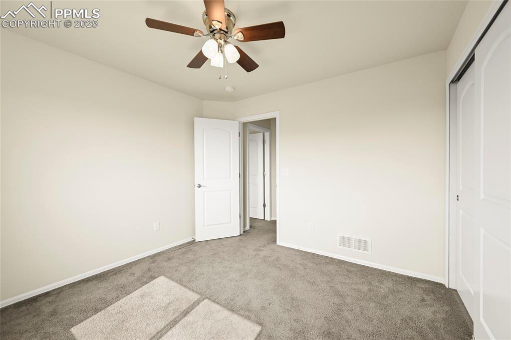 Image 21 of 28: Unfurnished bedroom with carpet flooring, a ceiling fan, and a closet