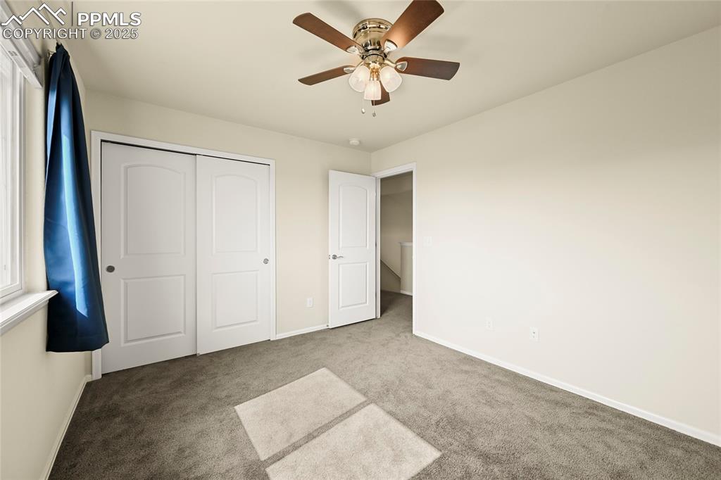 Image 24 of 28: Unfurnished bedroom featuring carpet flooring, a ceiling fan, and a closet