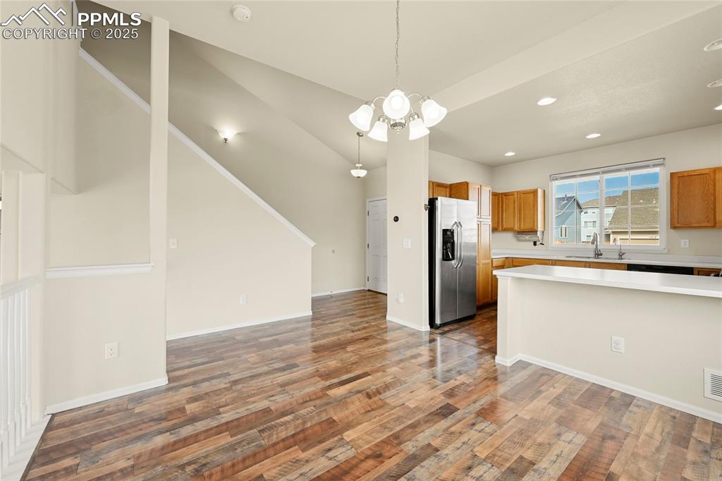 Image 5 of 28: Kitchen with decorative light fixtures, open floor plan, light countertops,