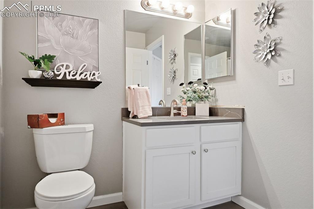 Image 18 of 32:  Second bathroom is a 3/4 with new quartz countertop and wood laminate floo